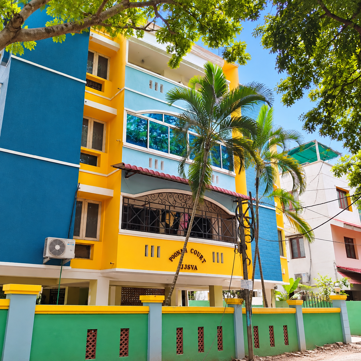 Colorful Apartment Facade Beneath Palm Trees Spacious Home for Rent - Image 1